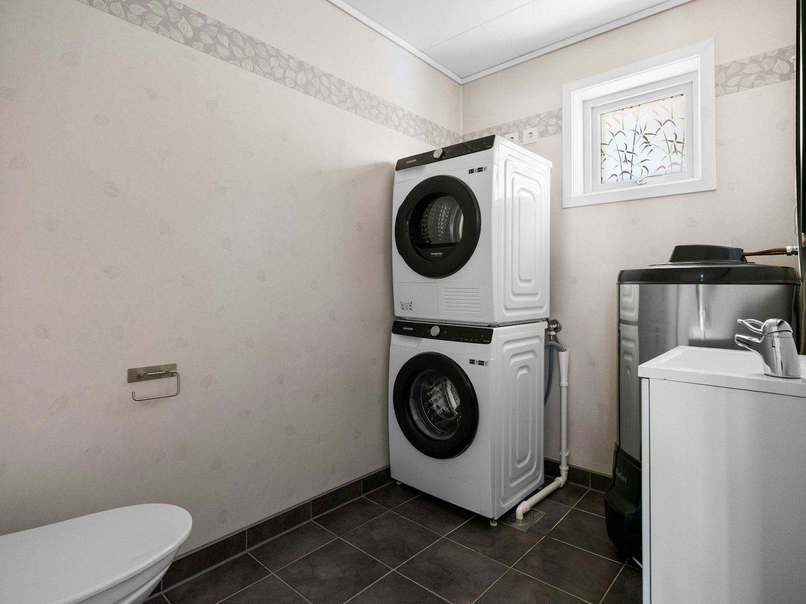 Person wischt die Innenseite einer Trocknertrommel mit einem Tuch aus