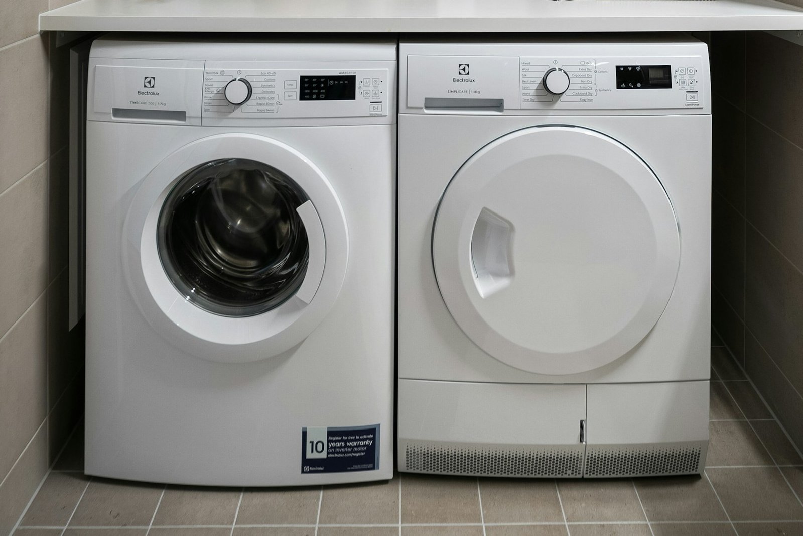 Person wischt die Innenseite einer Trocknertrommel mit einem Tuch